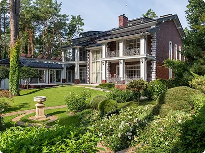 yeşillik ve bakımlı bahçe ile çevrili büyük tuğla villa