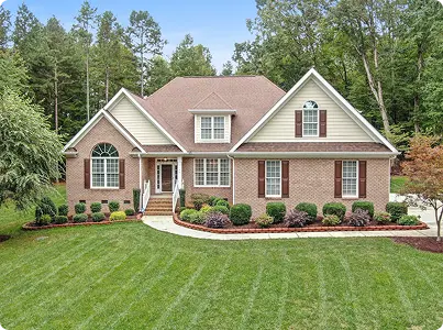 geniş çim alan ve ağaçlarla çevrili klasik aile evi